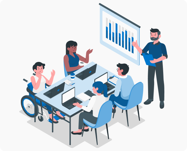 A meeting of people with disabilities. A facilitator stands beside a white board while participants with laptops sit at a table taking notes and brainstorming.